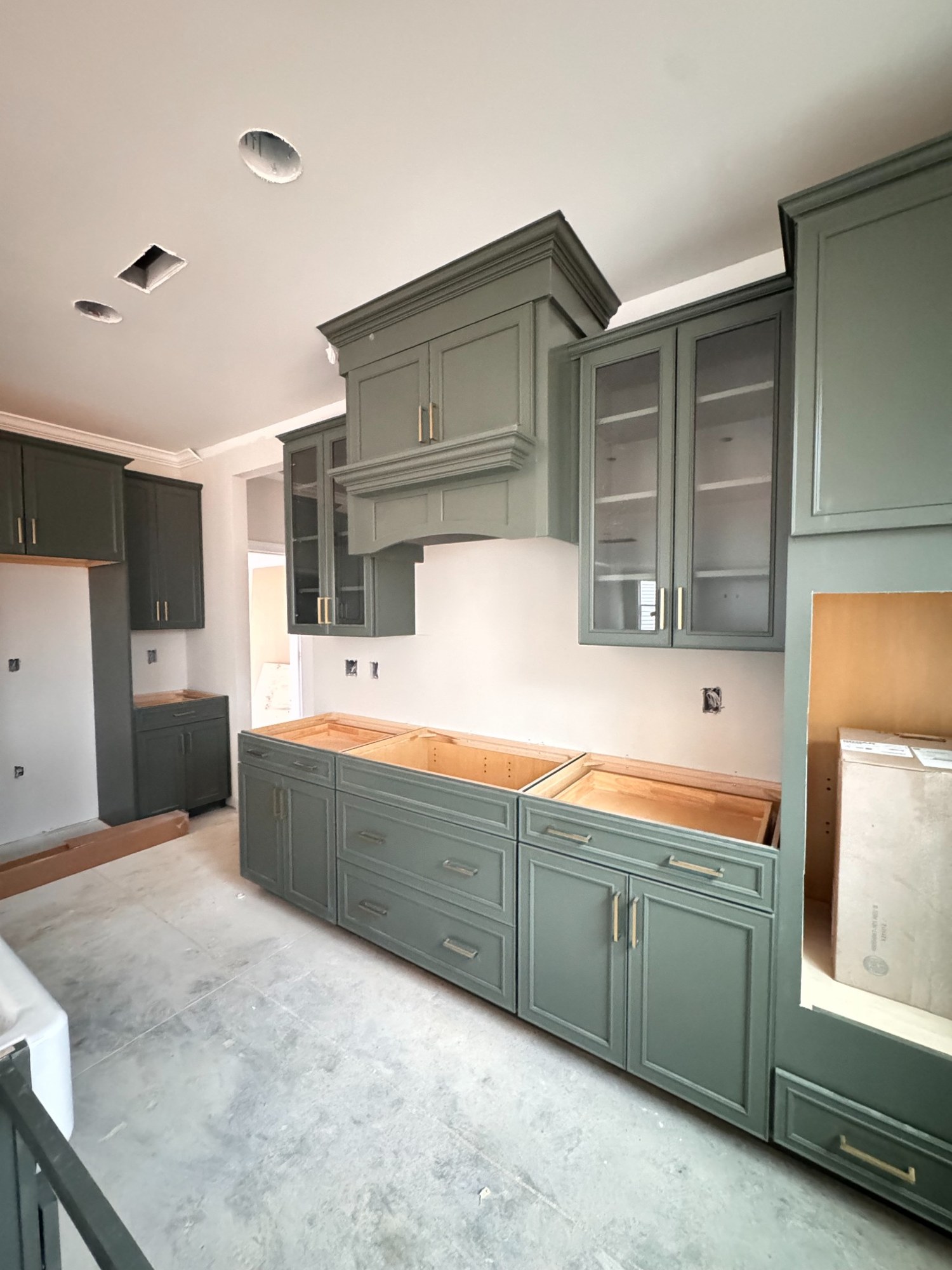 Green kitchen cabinetry being installed